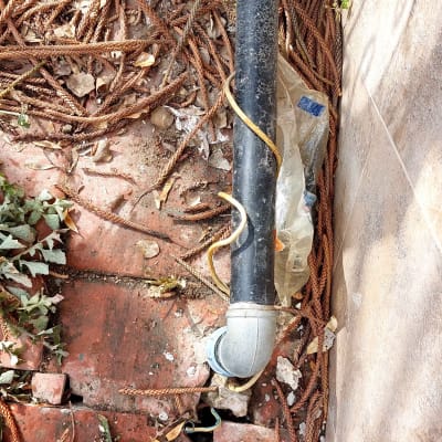 צינור שחור עם מחברים על רצפה מלוכלכת