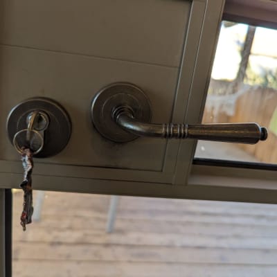 מנעול עם מפתח תלוי ודלת עם ידית מתכת