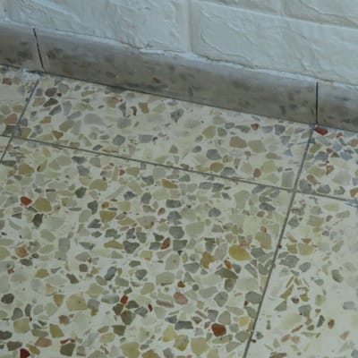 רצפה עם אריחים מלוכלכים ליד קיר לבן