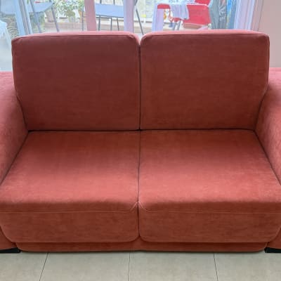 ספה אדומה בחדר עם חלונות גדולים