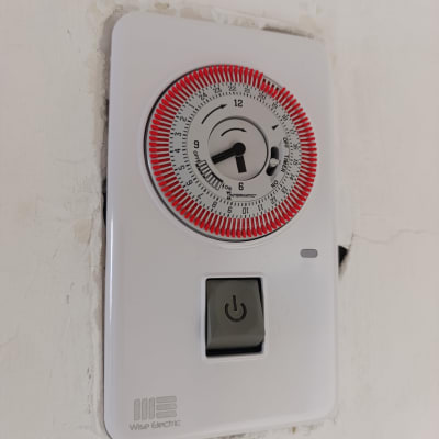 מתג חשמלי עם טיימר על קיר לבן