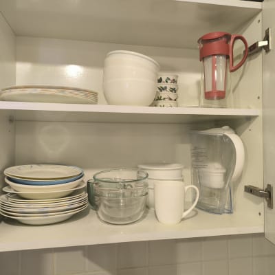 ארון מטבח עם צלחות, קערות, כוסות וקנקן מים