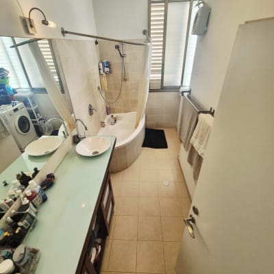 חדר אמבטיה עם כיור, אמבטיה ומכונת כביסה