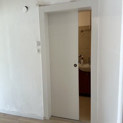 דלת לבנה חלקית פתוחה עם ידית עגולה