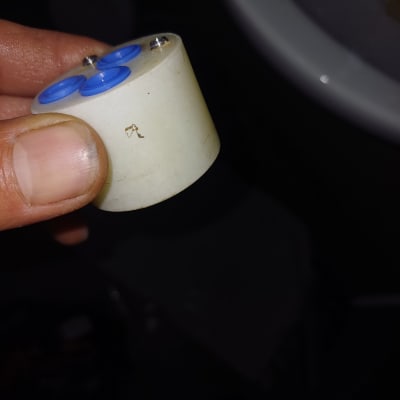 חלק פלסטיק עם חורים כחולים ביד של אדם