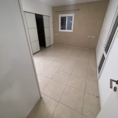 חדר ריק עם רצפת קרמיקה נקייה וקירות בהירים