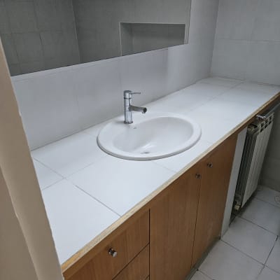 כיור נקי עם ארון עץ בחדר אמבטיה