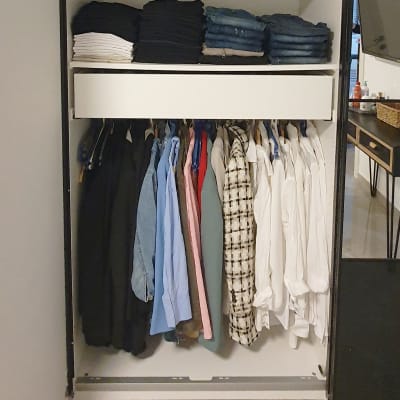 ארון בגדים מסודר עם בגדים תלויים ומקופלים