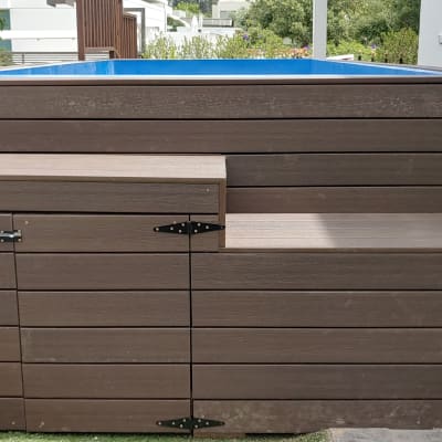 מבנה עץ חום עם בריכה כחולה עליונה