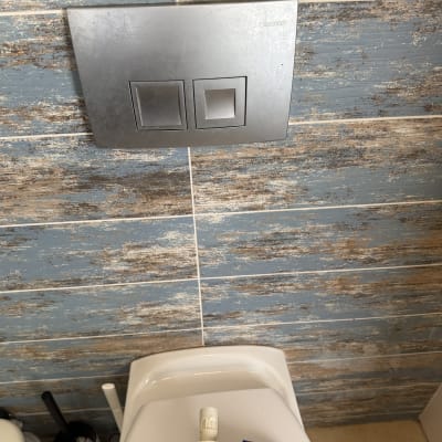 חלקי אסלה וכלים סניטריים על רקע קיר אריחים