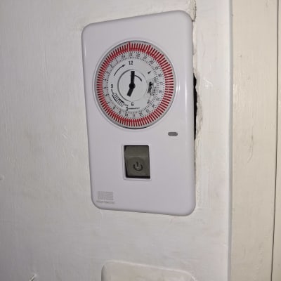 טיימר חשמלי על קיר עם כפתור הפעלה