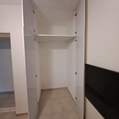 ארון פתוח עם דלתות לבנות בחדר ריק