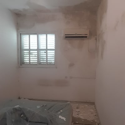 קירות עם כתמי צבע, מיטה מכוסה בניילון