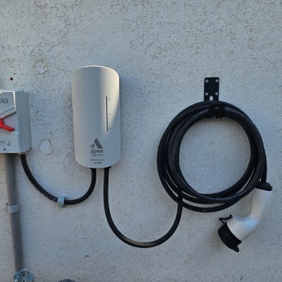 עמדת טעינה לרכב חשמלי עם כבל מחובר לקיר