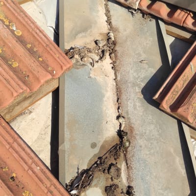 רעפים שבורים על גג עם לכלוך ופסולת