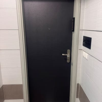 דלת מתכת כהה עם ידית כסופה ומנעול