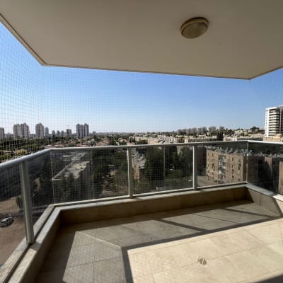 רשת יונים מותקנת במרפסת עם נוף עירוני