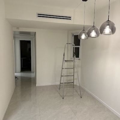 סולם מתכת בחדר עם תאורה תלויה על תקרה לבנה.