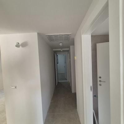 מסדרון צבוע בצבע לבן עם דלתות פתוחות