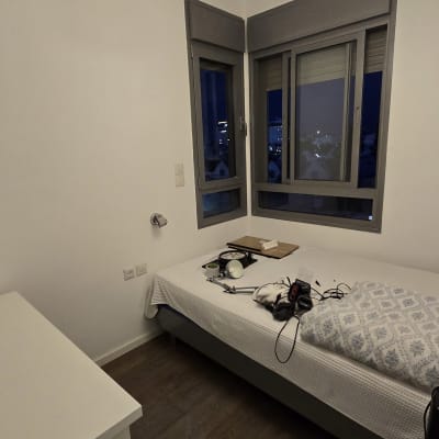 חדר עם מיטה, חלונות וכלים על המיטה