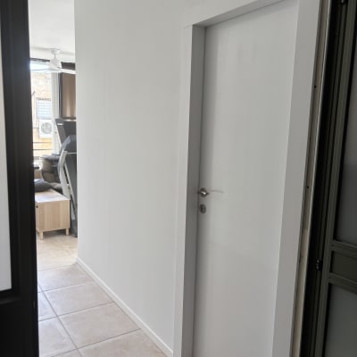 מסדרון עם דלת לבנה ורצפת אריחים