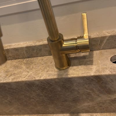 ברז זהב מותקן על משטח שיש במטבח