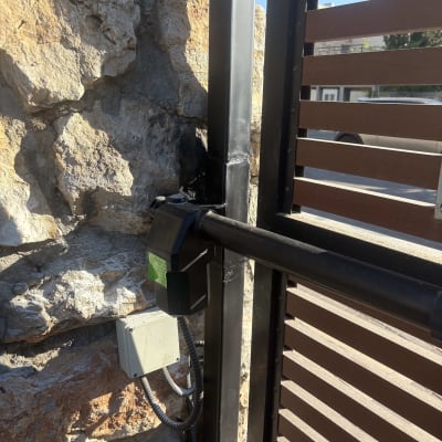 שער מתכת עם מנגנון נעילה על קיר אבן