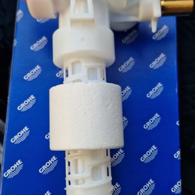 שסתום פלסטיק לבן על רקע קופסת גרוהה כחולה