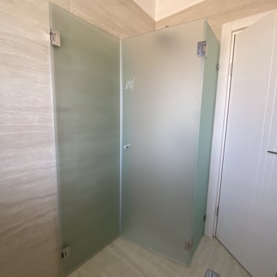 מקלחון זכוכית בחדר אמבטיה עם דלתות מטושטשות