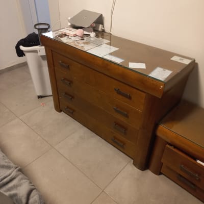 שידה מעץ עם מגירות וחפצים על השידה