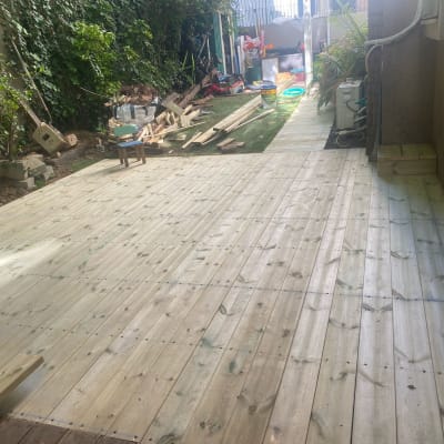 רצפת עץ חדשה עם קרשים וכלי עבודה בגינה