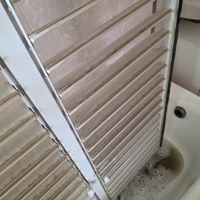 תריסים מלוכלכים באמבטיה עם מים וסבון