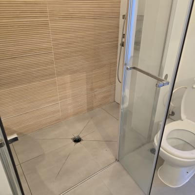 מקלחת חדשה עם אריחים ודלת זכוכית