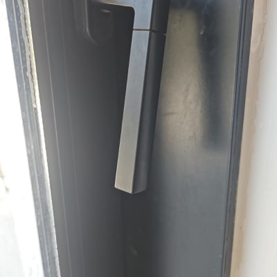 ידית חלון מתכתית על מסגרת שחורה