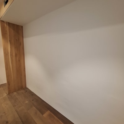 קיר צבוע בלבן עם רצפת עץ