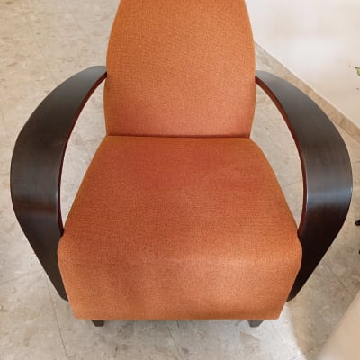 כורסה מרופדת בבד כתום עם ידיות עץ כהות