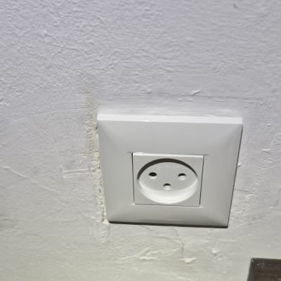 שקע חשמלי בקיר לבן עם צל