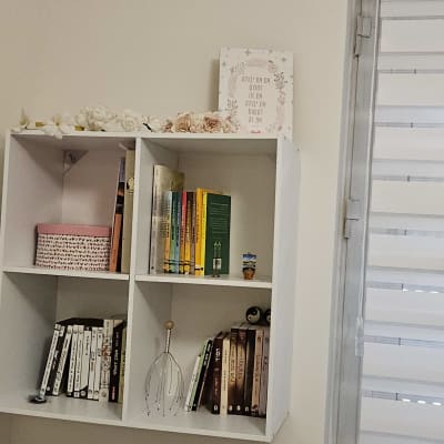 מדף עם ספרים וכלי עיסוי ראש