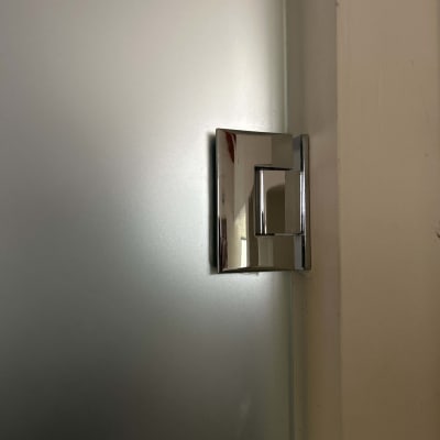 ידית מתכת על דלת זכוכית חלבית