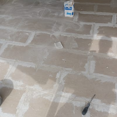 שק מלט וכלי עבודה על רצפת אריחים