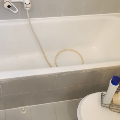 אמבטיה עם צינור מים ומדף בקבוקים