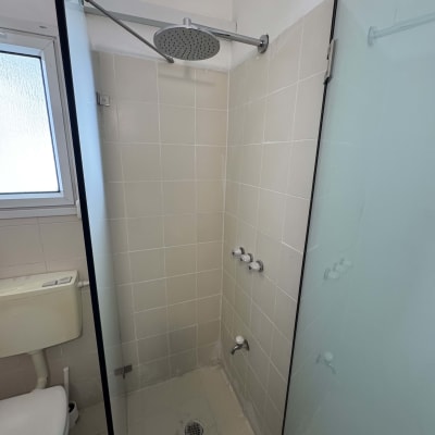 מקלחת עם ראש מקלחת עגול ודלת זכוכית