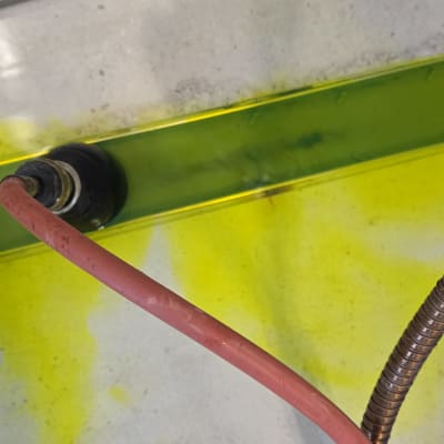 צינור אדום ונוזל צהוב על משטח בטון