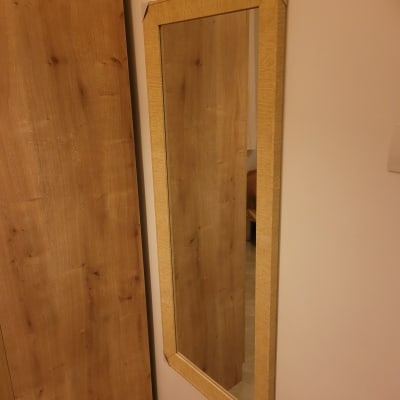 מראה תלויה על קיר עם מסגרת עץ