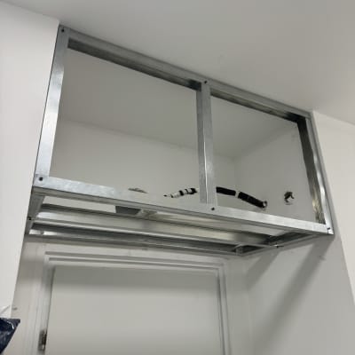 מסגרת מתכת מותקנת מעל דלת לבנה