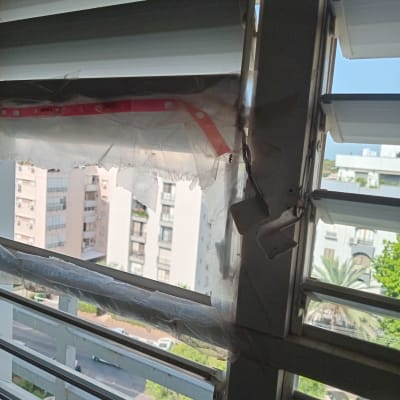 תריסים שבורים עם נוף עירוני ברקע