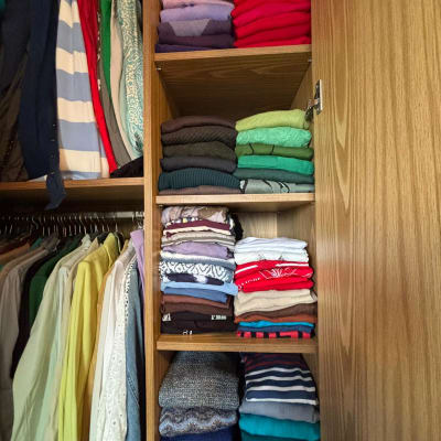 בגדים מקופלים ומסודרים בארון עץ