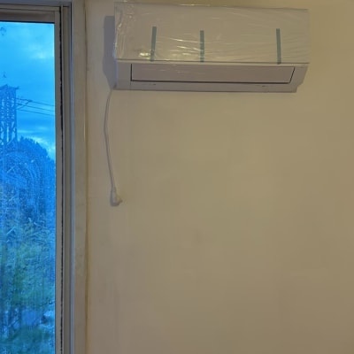 מזגן מותקן על קיר עם כבל חשמל תלוי