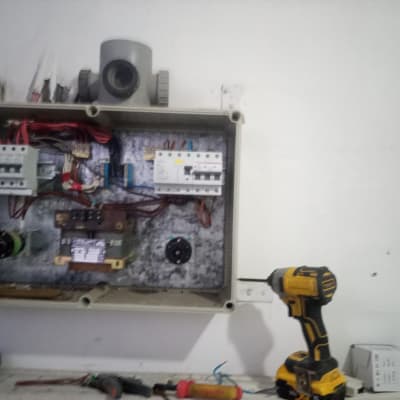 לוח חשמל פתוח עם כלים חשמליים על השולחן