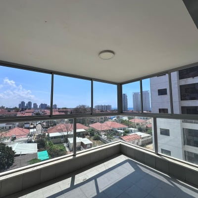 חלונות אלומיניום במרפסת סגורה עם נוף עירוני